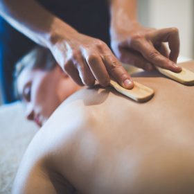 Thai massage therapist treating patient at healthcare salon